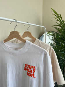 Rack with two t-shirts with front print that reads "exploration". One tee is white and the other cream