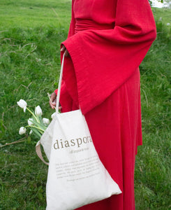 Close up of girl wearing red maxi dress holding tote bag with tulips/